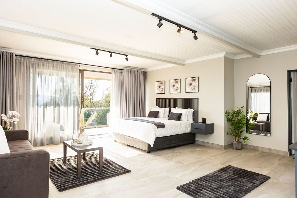Spacious en-suite bedroom with a lounge area and balcony at The Victoria Bed & Breakfast, Newcastle