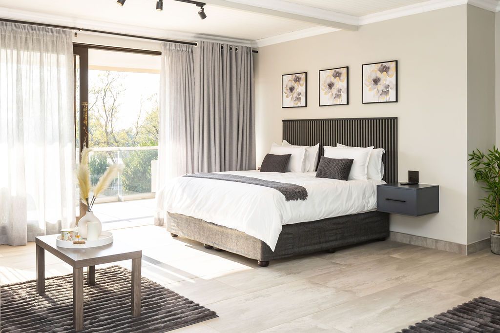 Spacious light-filled bedroom with a seating area and large windows